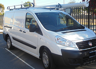 a white van parked in a parking lot with Jaram Tradesmen roof rack on top